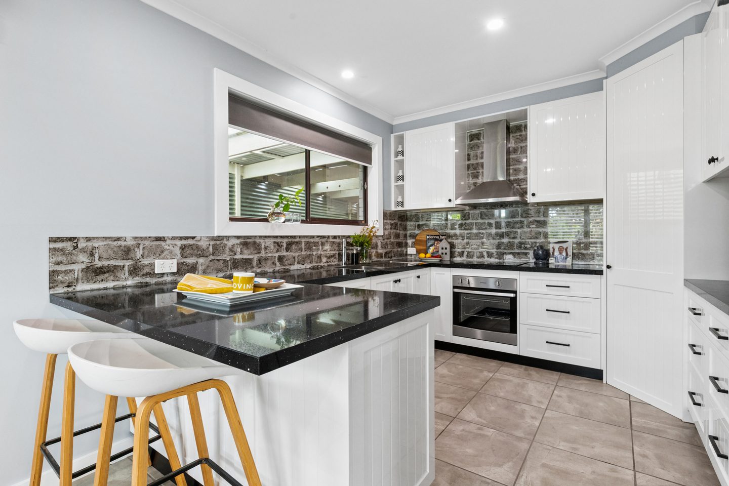 Kitchen with a breakfast bar and white cabinetry