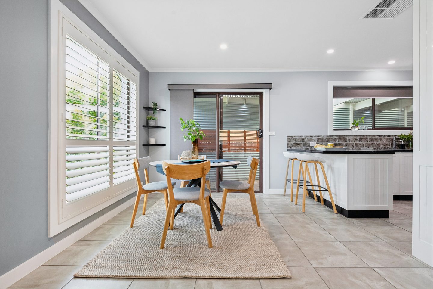 Dining area with shutters and access to the patio