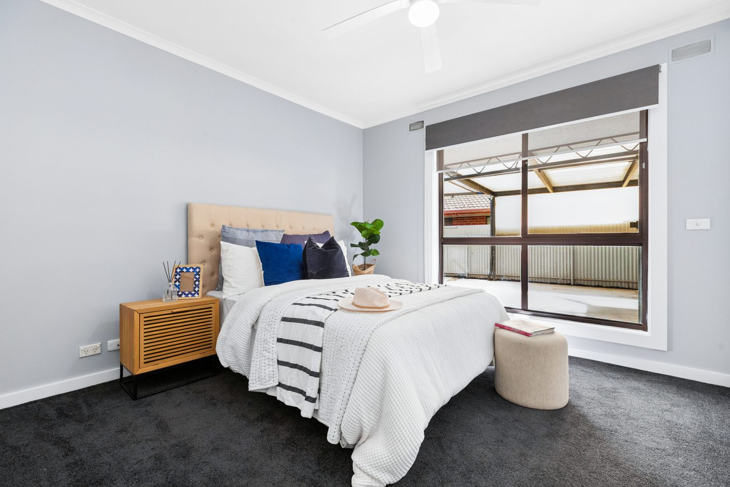 Carpeted bedroom with a ceiling fan
