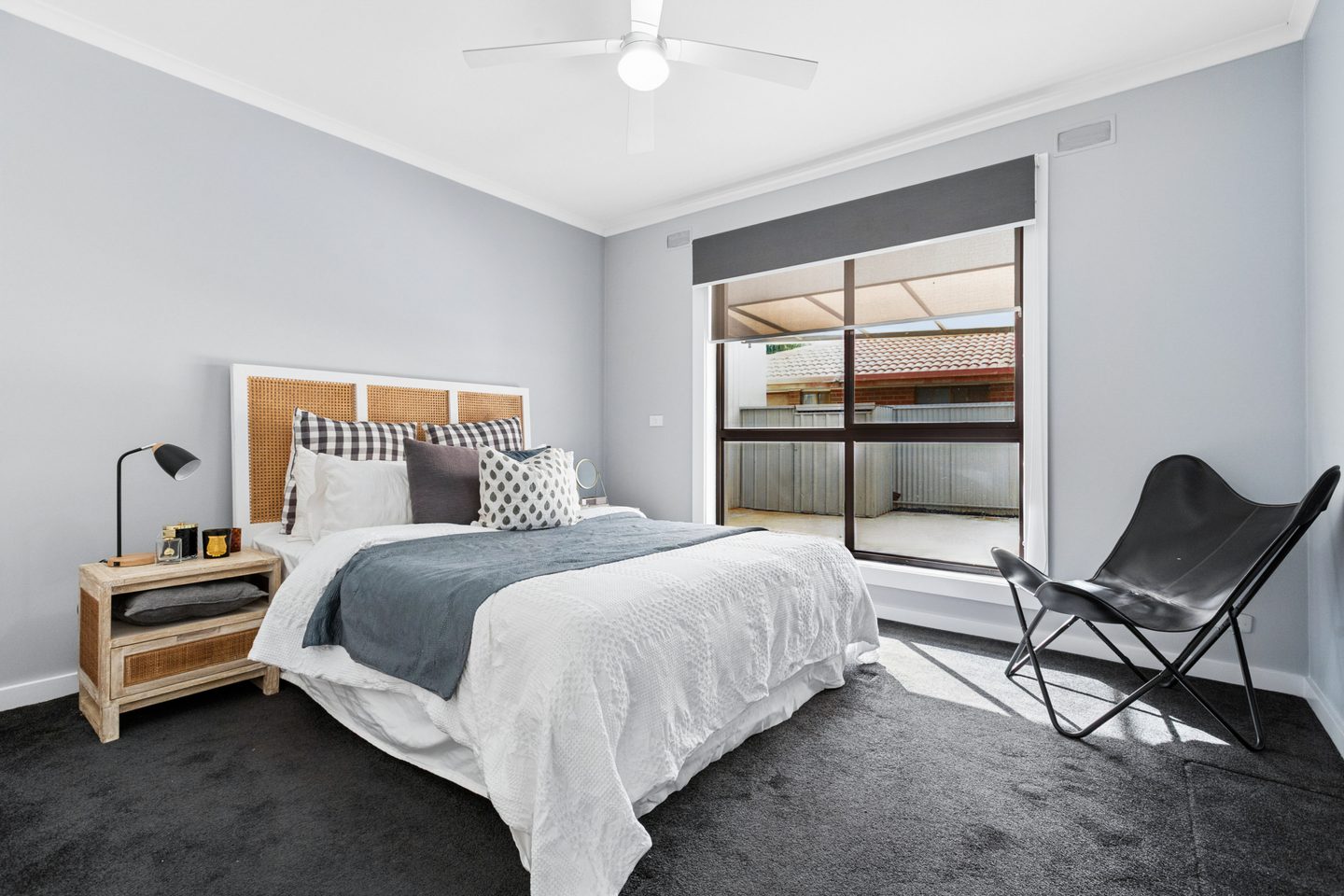 Bedroom with a ceiling fan and window to the covered area