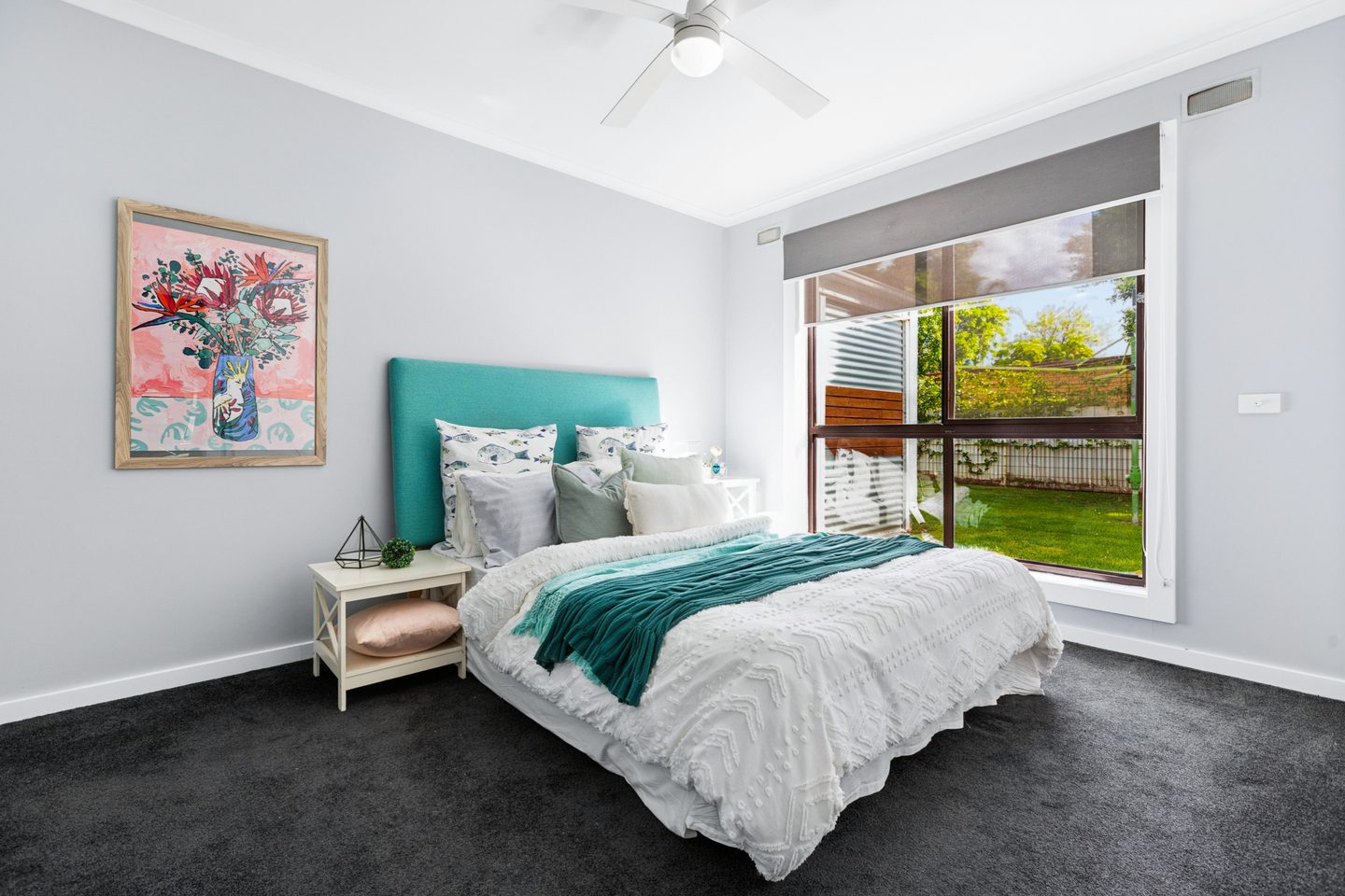 Carpeted bedroom with a ceiling fan and garden-facing window