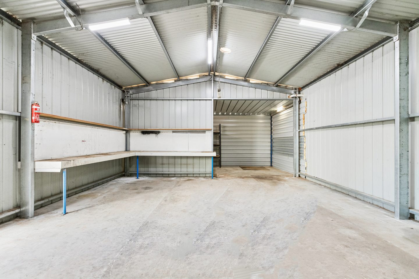 Interior of the shed with a workbench and concrete floor